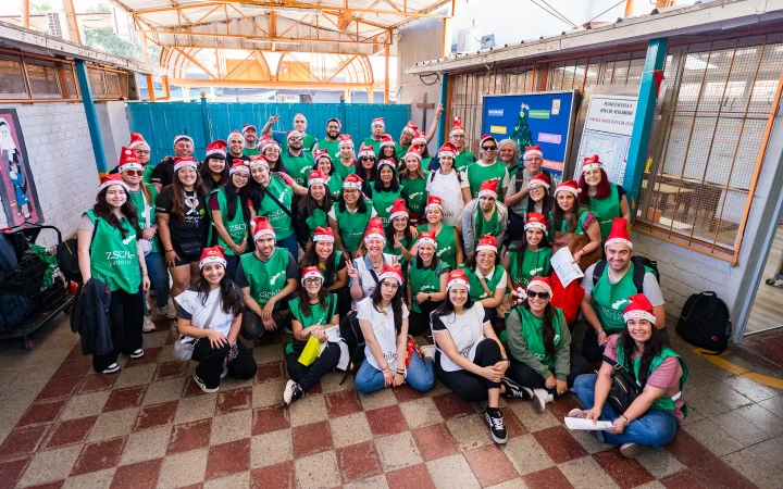 más de cincuenta colaboradores de Zurich Santander en grupo con sus pecheras y gorros navideños.