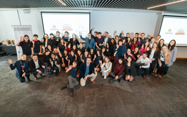 Fotografía de un grupo de personas que incluye colaboradores de Zurich Santander y estudiantes del colegio Lorenzo Sazié, en el marco de la ceremonia de inicio del Programa de Tutorías, junto a la Fundación Belén Educa